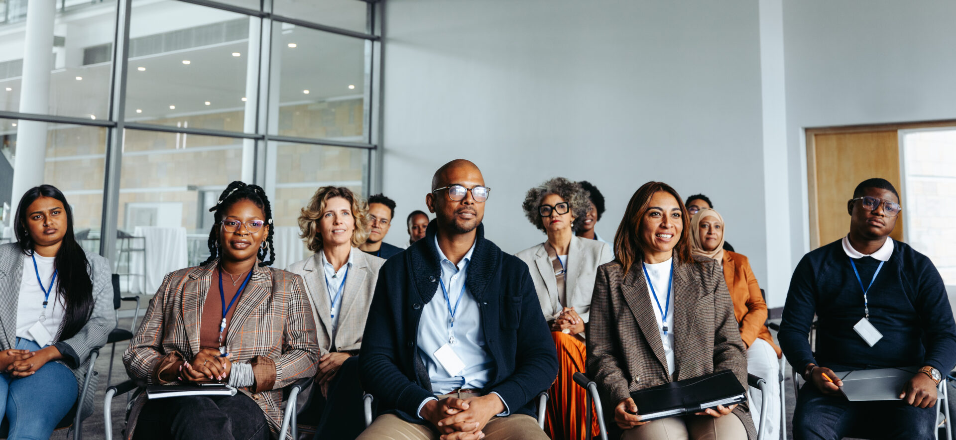 Diverse group of professionals attending a work conference in a modern office setting Diverse group of professionals engaged in a work conference, showcasing teamwork and collaboration in a modern office environment.